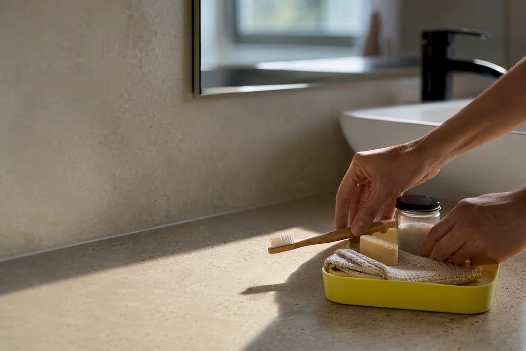 Hands arranging plastic-free bathroom swap materials