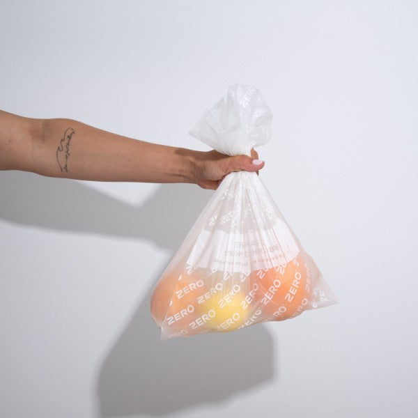 Hand holding a ZERO compostable produce bag filled with fruit