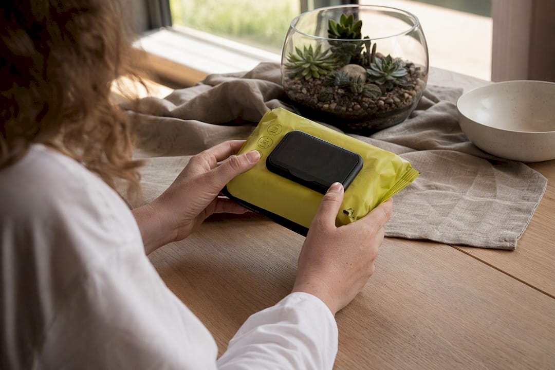 Hands inspecting biodegradable wipe packaging