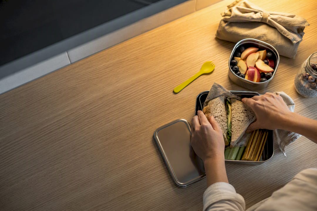 Hands packing a plastic-free school lunch